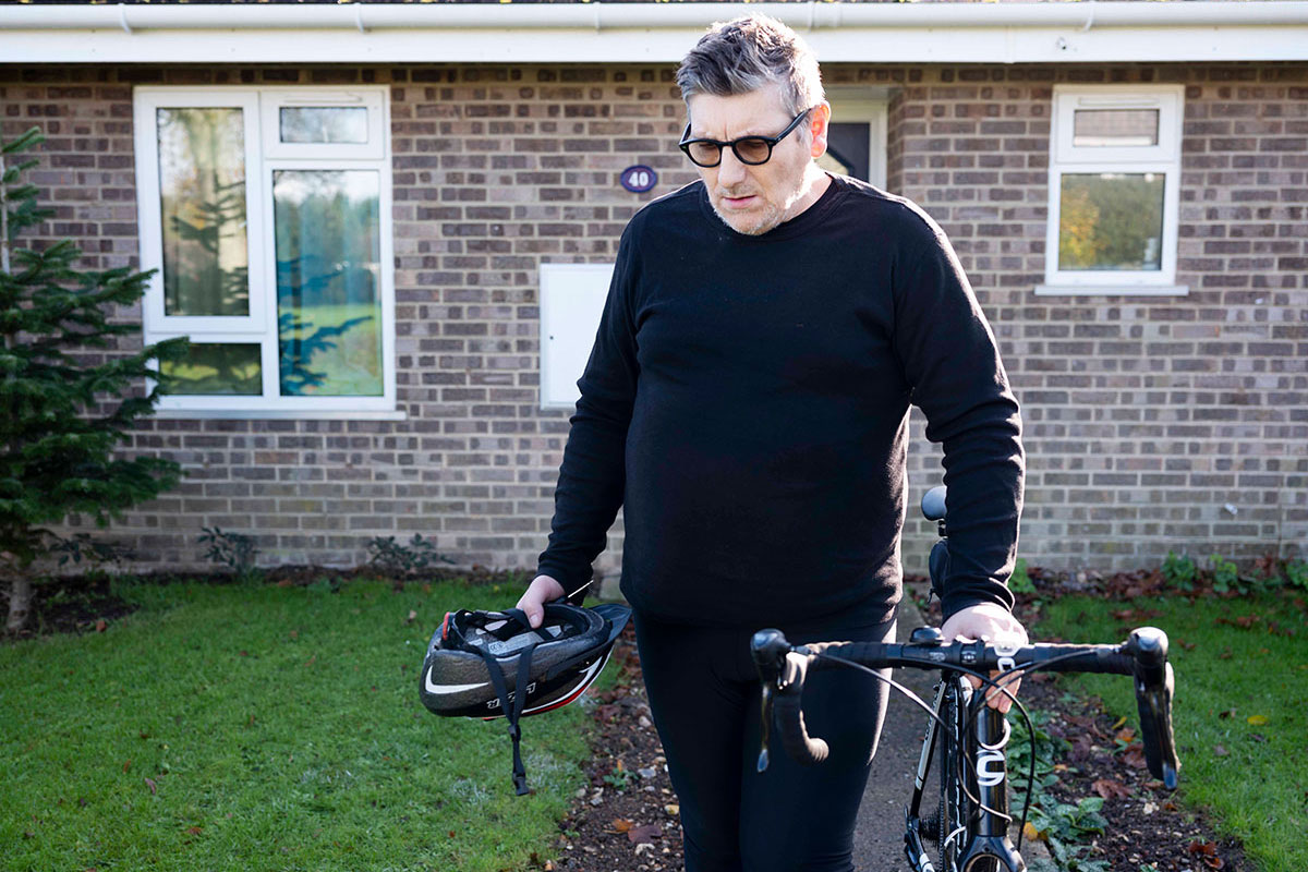 Wynford with his bike holding bike helmet in hand